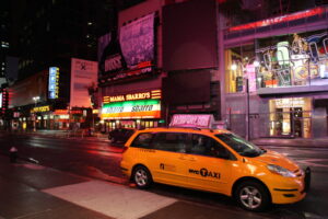 Yellow hvc taxi on road during night
